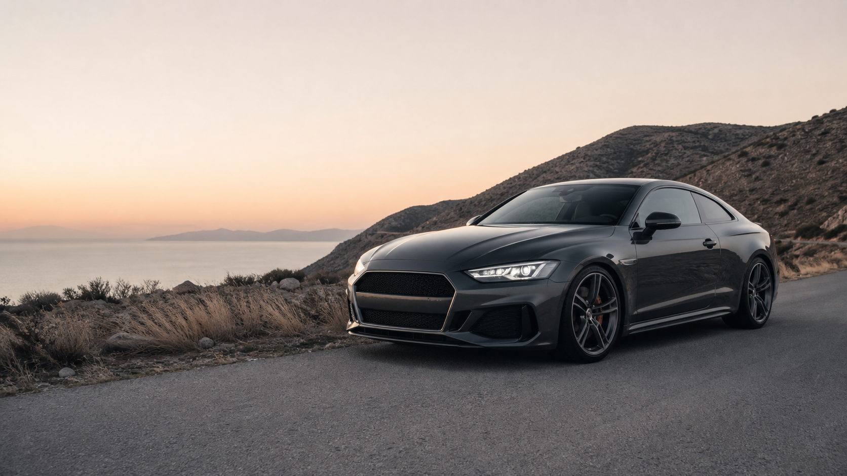 Charcoal performance coupe on a coastal road